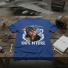 Pilot cat wearing aviator sunglasses and helmet with "100% MTURE" text, flying a fighter jet, on a blue t-shirt