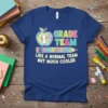 1st Grade Team Like A Normal Team But Much Cooler text design with apple and pencil graphics on a blue