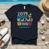 2019 Newlywed Cruise text with anchor, waves, flip-flops, and heart graphic on navy t-shirt
