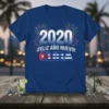 Blue t-shirt with "2020 ¡FELIZ AÑO NUEVO! CUBA" text and Cuban flag design, surrounded by fireworks