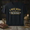 Black t-shirt with gold text: "3 WISE MEN? Be Serious" in a festive, slightly distressed font, featuring star accents