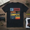 Black t-shirt with "4th Grade Level Complete" text design featuring a graduation cap and video game controller graphic