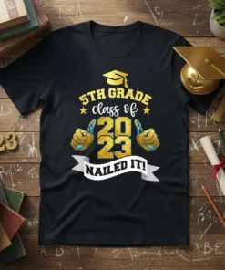 Black t-shirt with "5TH GRADE class of 2023 NAILED IT!" text, graduation cap, and thumbs-up graphics