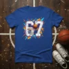 Blue t-shirt featuring a large white cracked number 67 with a basketball going through a net, surrounded by colorful abstract