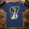 T-shirt design featuring the number 67 with a thumbs-up hand gesture and retro swirling graphics