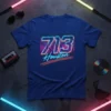 713 Houston neon text with city skyline graphic on a blue t-shirt