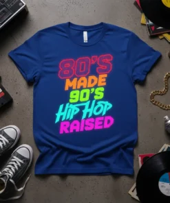 Bold neon text graphic "80's Made 90's Hip Hop Raised" on a royal blue t-shirt, representing 80s and 90s music