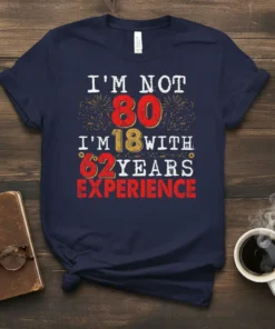 T-shirt with the text "I'm Not 80 I'm 18 With 62 Years Experience" in distressed vintage font with fireworks graphics