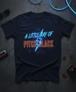 A Little Ray Of Pitch Black text in neon blue and orange on a dark t-shirt with a lightning bolt