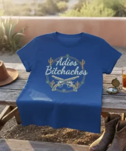 Adios Bichachos text with crossed revolvers, cacti, and rope border on a blue t-shirt