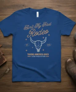Blue t-shirt with "Ain't My First Rodeo" and "Taking America Back" text, featuring a bull skull graphic and "Ultra Maga