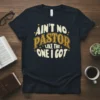 Ain't No Pastor Like The One I Got quote on a dark navy t-shirt, featuring retro-style typography in yellow and