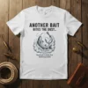 White t-shirt with black text "ANOTHER BAIT BITES THE DUST" above a graphic of a fish being reeled in, with