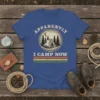 Apparently I Camp Now t-shirt featuring a vintage circular design with a tent, pine trees, moon, and stars, above retro