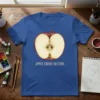 Apple Cross-Section T-Shirt featuring a detailed watercolor illustration of a sliced apple with text "APPLE CROSS-SECTION"