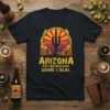 Arizona Craft Beer Revolution Drink Local text with a desert cactus and sunset graphic on a black t-shirt