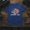 Arrest This slogan with a raised fist and distressed American flag graphic on a blue t-shirt