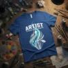 Artist t-shirt with bold white text "ARTIST THE POWER OF CREATION IS WITHIN YOU" and abstract flame graphic with paintbrushes