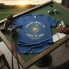 Blue t-shirt with "Ask Me About My Hole In One" text and a golf ball on a tee graphic