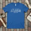 Atlanta skyline graphic with "ATLANTA SINCE 1843" text in white outline on a blue t-shirt