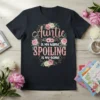 Auntie is my name SPOILING is my game quote with floral wreath on a black t-shirt
