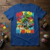 Autism Is My Superpower T-Shirt with a green dinosaur and monster truck on a colorful puzzle background