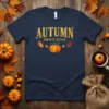Navy t-shirt with "AUTUMN HARVEST FESTIVAL" text and a pumpkin graphic, surrounded by autumn leaves