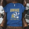 Awake But At What Cost t-shirt design featuring a grumpy badger holding a coffee cup and the quote in bold