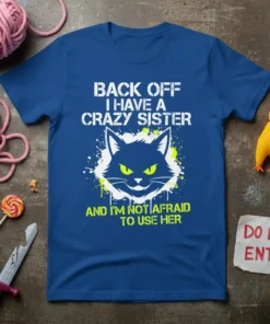 T-shirt with white text "BACK OFF I HAVE A CRAZY SISTER" above a black cat graphic and green text "AND