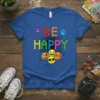 Blue t-shirt with "BE HAPPY" text in colorful emoji letters and a cluster of happy emoji faces below