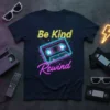 Be Kind Rewind text with neon cassette tape graphic on a dark t-shirt