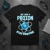 Be Like A Proton Stay Positive quote with atom graphic on a black t-shirt for science lovers