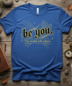 Blue t-shirt with "be you. The world will adjust." in gothic and simple fonts, framed by abstract golden geometric lines