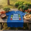 Blue t-shirt with "beans greens potatoes tomates" text and illustrations of vegetables like beans, cabbage, potatoes, and tomatoes