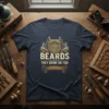 Beards They Grow On You quote with a vintage-style beard graphic on a navy t-shirt
