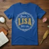 Blue t-shirt with "Because I'm LISA That's Why" text inside a decorative white circular frame, featuring glittery gold "LISA" text