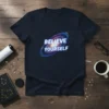 Navy t-shirt with "Believe In Yourself" text overlaying a swirling galaxy graphic
