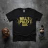 Black t-shirt with yellow "Bell's Palsy Sux" text and decorative branches, promoting awareness