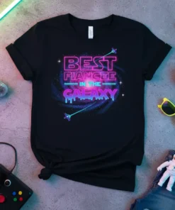 Best Fiancee In The Galaxy text design with neon pink and blue lettering on a black t-shirt, featuring a galaxy