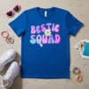 Bestie Squad text with groovy font and a happy daisy graphic on a royal blue t-shirt