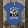 BEWARE GRUMPY BEAR CROSSING text with a roaring bear and mountain graphic on a blue t-shirt