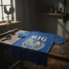 BIG Rooster graphic t-shirt in blue, featuring a detailed rooster illustration within a laurel wreath and the word BIG above