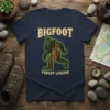 Bigfoot Forest Legend graphic tee featuring a bark-textured Bigfoot silhouette and bold text on a navy shirt