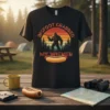 Bigfoot holding a hot dog with text "BIGFOOT GRABBED MY WIENER" on a vintage sunset graphic