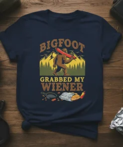BIGFOOT GRABBED MY WIENER t-shirt design with Bigfoot holding a hot dog, mountains, and grilling elements