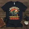 Bigfoot Grabbed My Wiener T-Shirt with retro sunset graphic and Bigfoot holding a hot dog