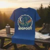Bigfoot T-Shirt with a vintage circular design featuring Sasquatch silhouette, moon, stars, and pine trees