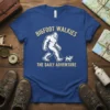BIGFOOT WALKIES THE DAILY ADVENTURE text design with Bigfoot walking a small dog, white and yellow on blue t-shirt