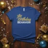 Birthday BEHAVIOR text with a golden crown graphic on a royal blue t-shirt, perfect for birthday celebrations