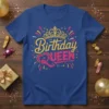 Birthday Queen text with a glittering crown and festive accents on a blue t-shirt